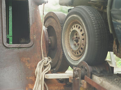 Car tire resting on idler and hammer drive gear